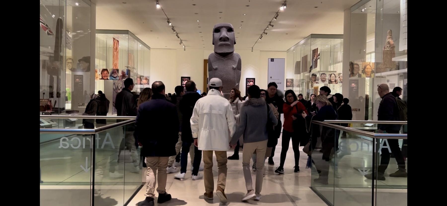 Visitors gathered around a large Moai statue in the British Museum's public galleries, London