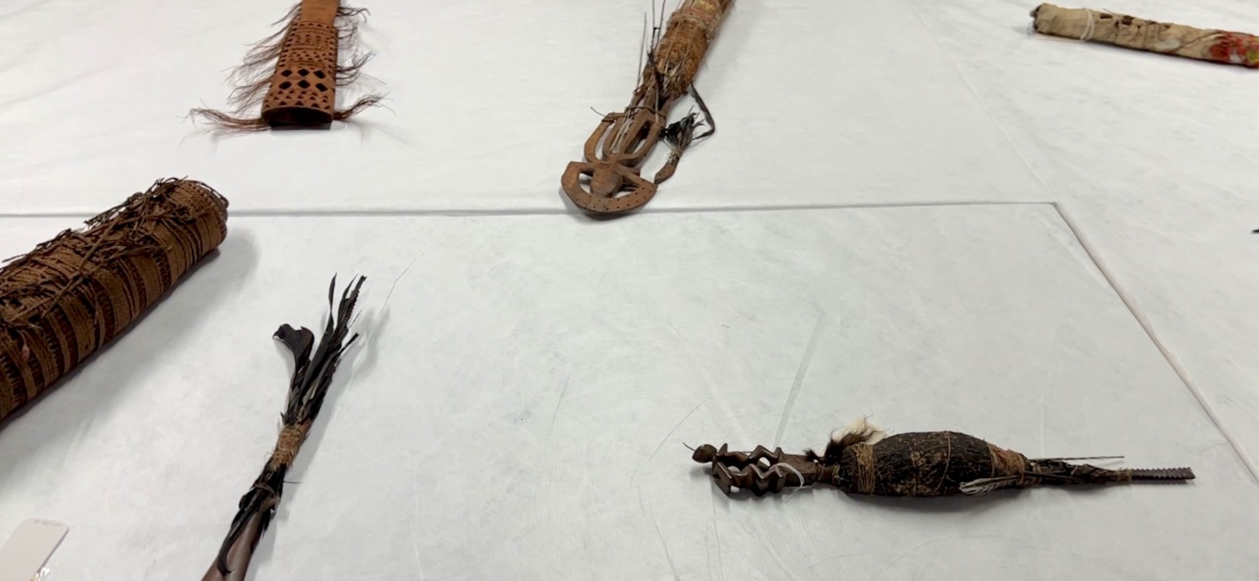 Sacred Polynesian taoa artefacts from the London Missionary Society collection, laid out for documentation at the British Museum