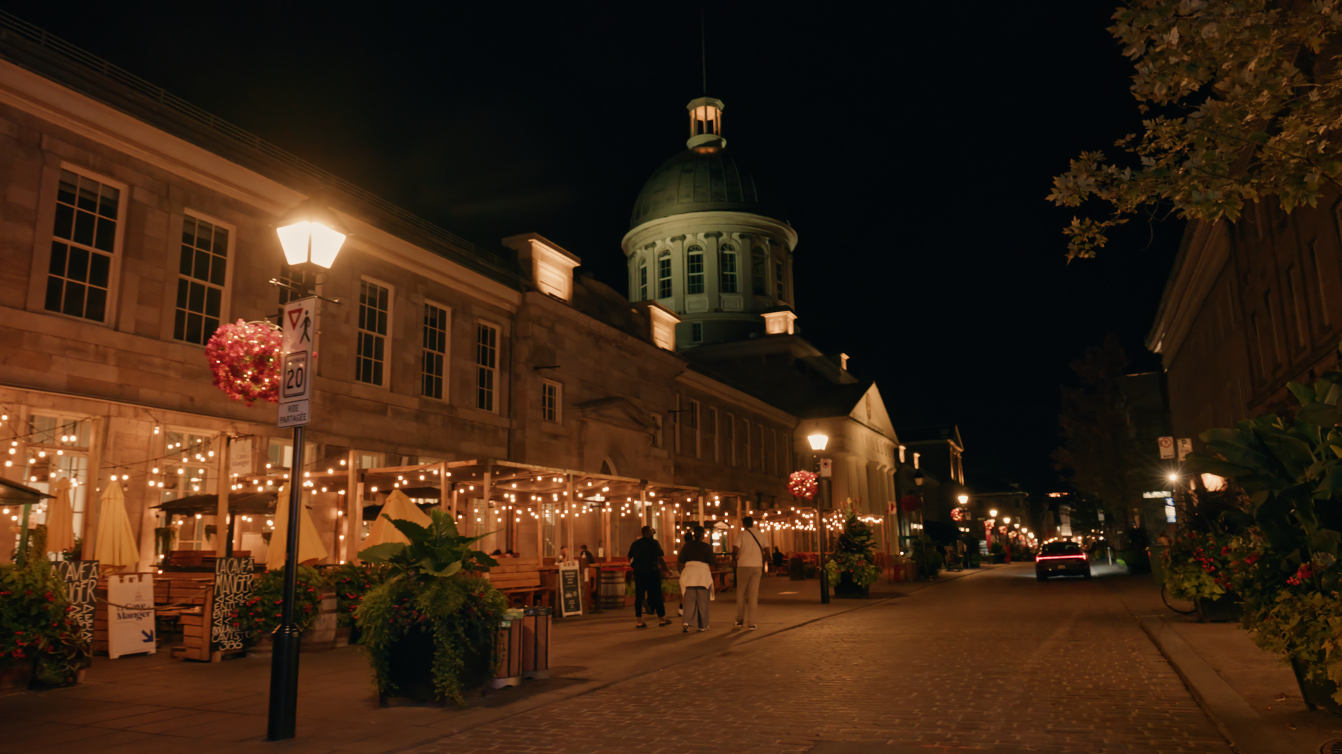 Bonsecours Market lit up at night above a cobbled street in Old Montreal